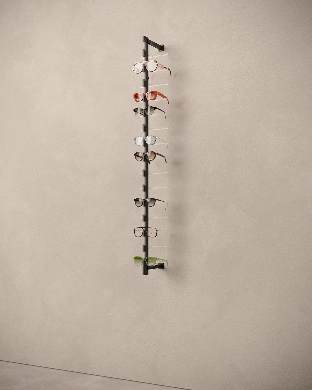Eyewear rod with multiple pairs of eyeglasses on a beige wall.