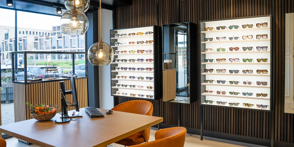 Optical cabinets in a modern interior setting with a table and chairs.