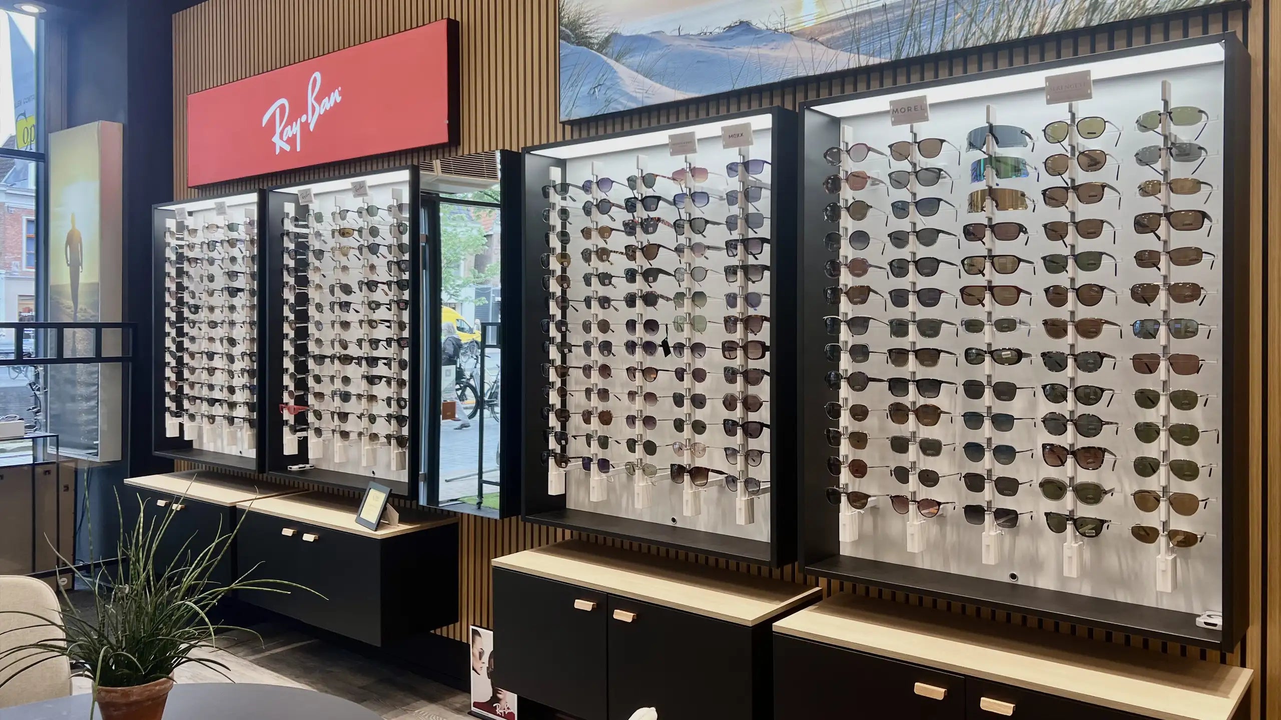 Eyewear cabinet with Ray-Ban sunglasses in an optical store.