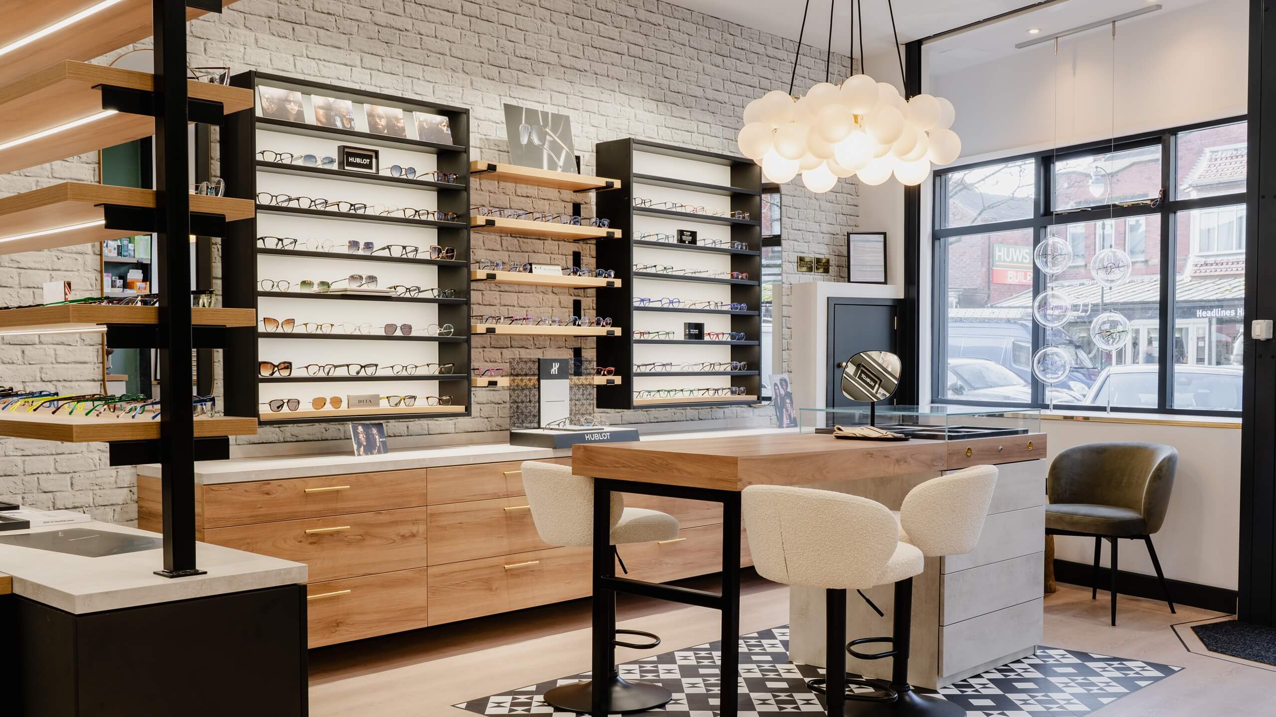 Modern optical interior with wooden counters, cabinets with shelves, and a large window, part of optical store projects